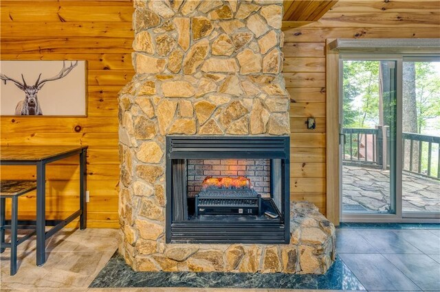 details featuring wooden walls and a stone fireplace