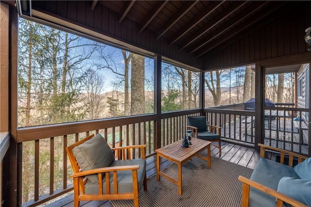 sunroom / solarium with vaulted ceiling with beams