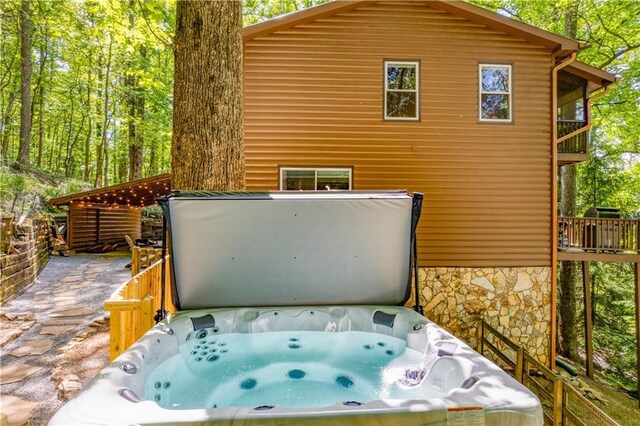 exterior space with stone siding and a jacuzzi