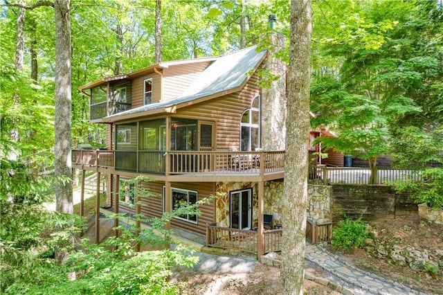 back of property featuring faux log siding and a deck