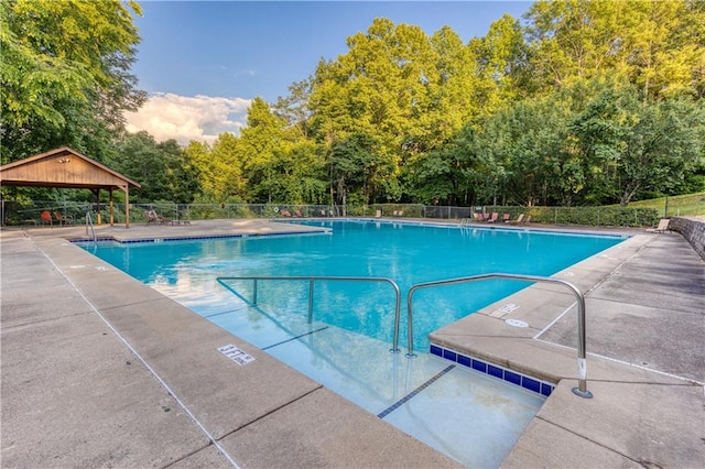 pool with fence, a patio, and a gazebo