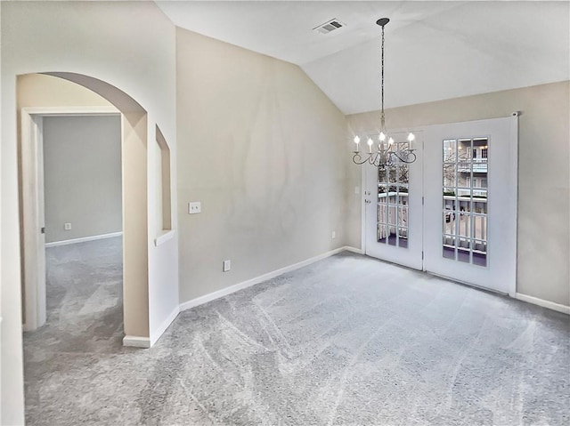 carpeted spare room featuring a chandelier and lofted ceiling