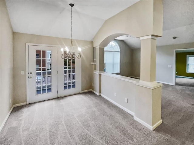 unfurnished room featuring lofted ceiling, carpet flooring, and an inviting chandelier