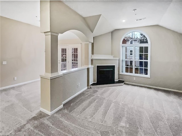 unfurnished living room featuring ornate columns, carpet, and lofted ceiling