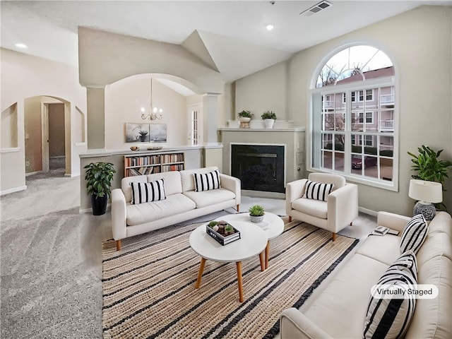 living room featuring an inviting chandelier, light colored carpet, and lofted ceiling