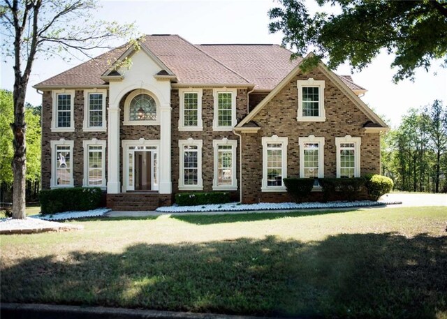 view of front facade featuring a front yard and brick siding