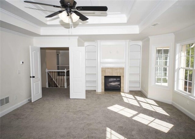 unfurnished living room featuring ornamental molding, a tray ceiling, visible vents, and carpet floors