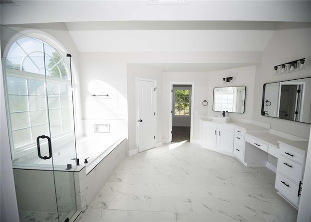 full bathroom featuring a bath, marble finish floor, vanity, and lofted ceiling