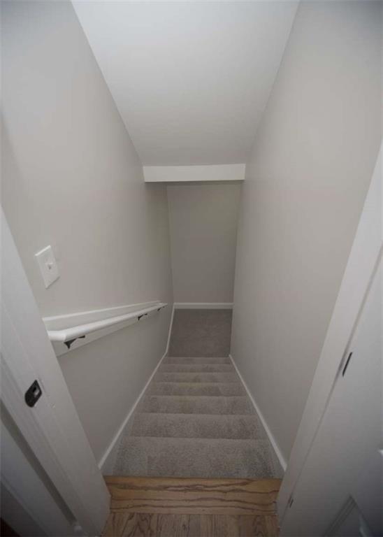 staircase with baseboards and carpet floors