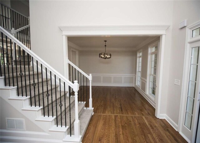 foyer entrance featuring a chandelier, visible vents, and stairway