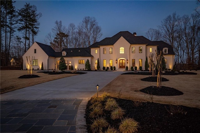 view of front of property with curved driveway and stucco siding