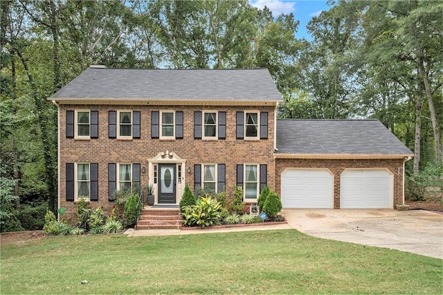 colonial house featuring a garage and a front lawn