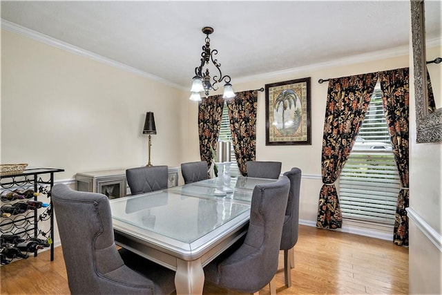 dining room featuring a notable chandelier, light wood-type flooring, and crown molding