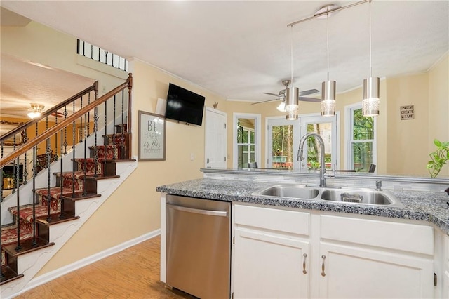 kitchen featuring light hardwood / wood-style floors, sink, white cabinetry, hanging light fixtures, and stainless steel dishwasher