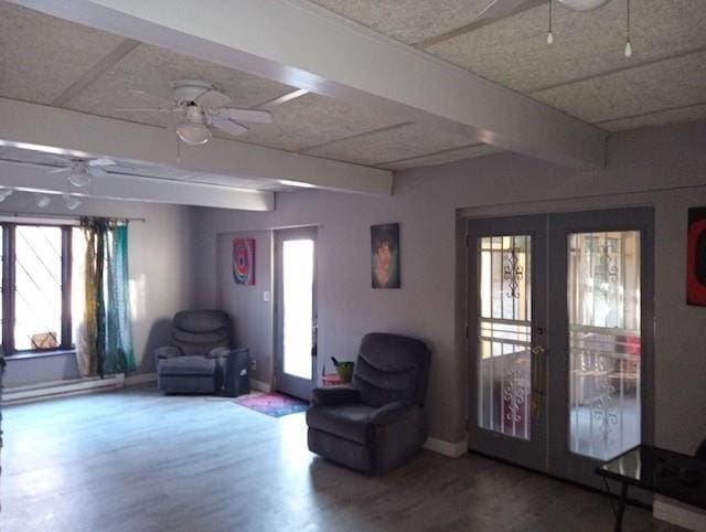 living area featuring ceiling fan, baseboard heating, hardwood / wood-style floors, french doors, and beamed ceiling