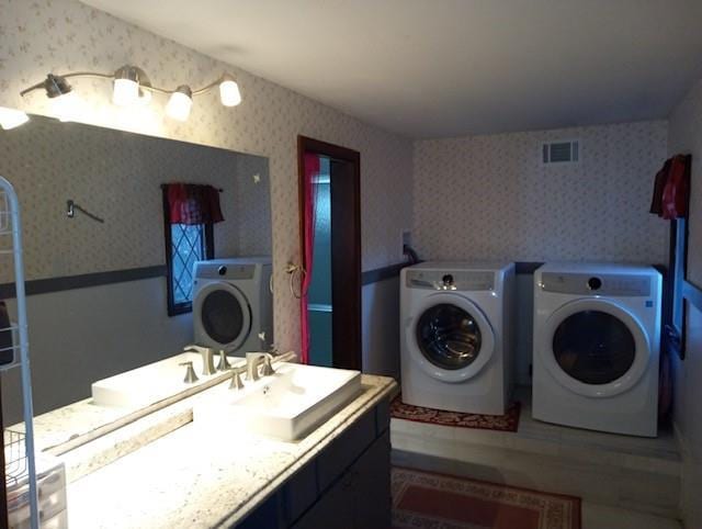 clothes washing area featuring washing machine and clothes dryer and sink