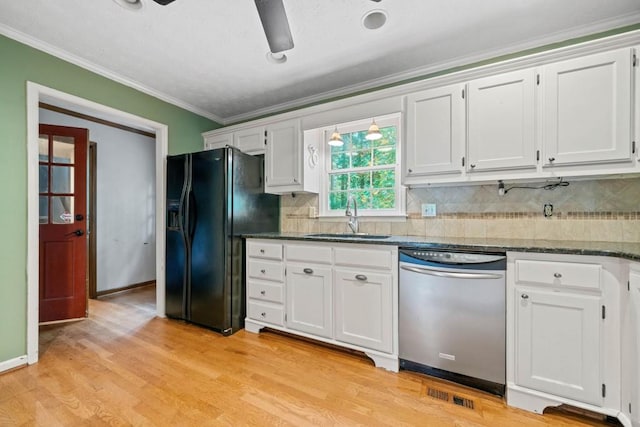 kitchen with a sink, stainless steel dishwasher, white cabinets, and black refrigerator with ice dispenser