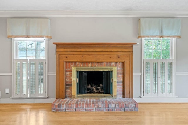 room details featuring a fireplace, crown molding, and wood finished floors