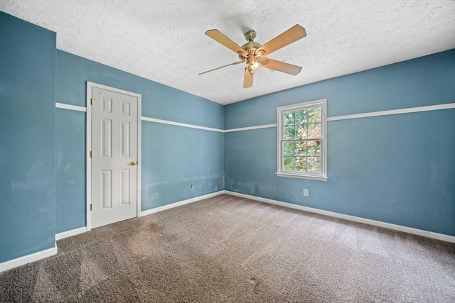 carpeted spare room with a textured ceiling, baseboards, and ceiling fan