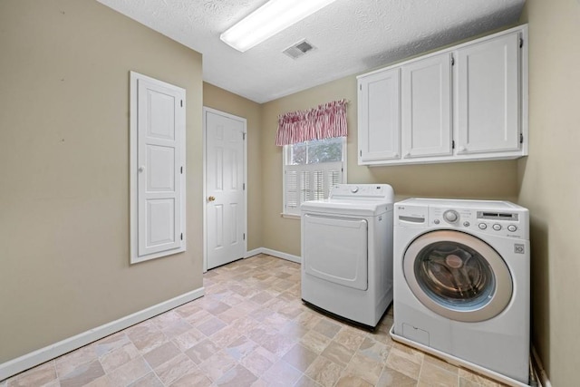 laundry room featuring visible vents, baseboards, cabinet space, a textured ceiling, and separate washer and dryer