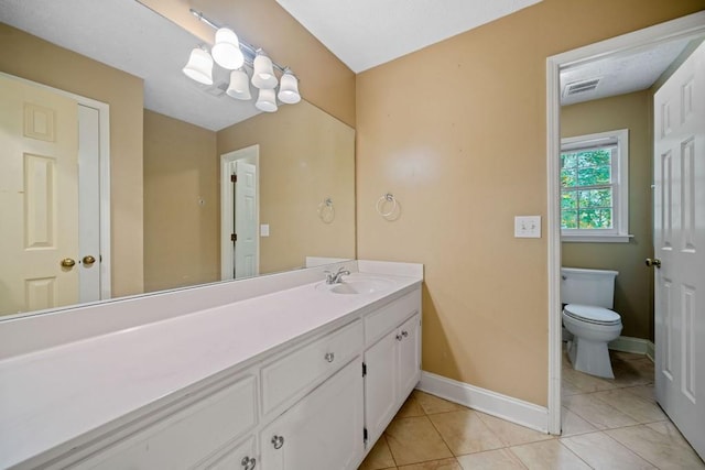 bathroom with visible vents, baseboards, toilet, tile patterned floors, and vanity