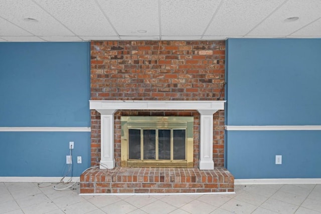 interior details with a paneled ceiling, baseboards, and a fireplace