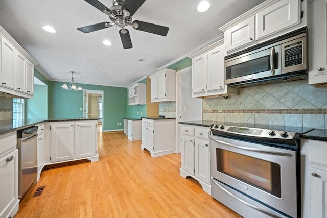 kitchen featuring white cabinetry, dark countertops, visible vents, and stainless steel appliances