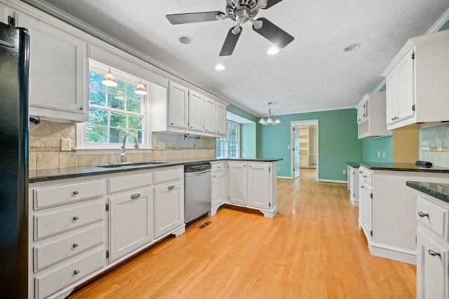 kitchen featuring a sink, freestanding refrigerator, light wood-style floors, a peninsula, and dishwasher