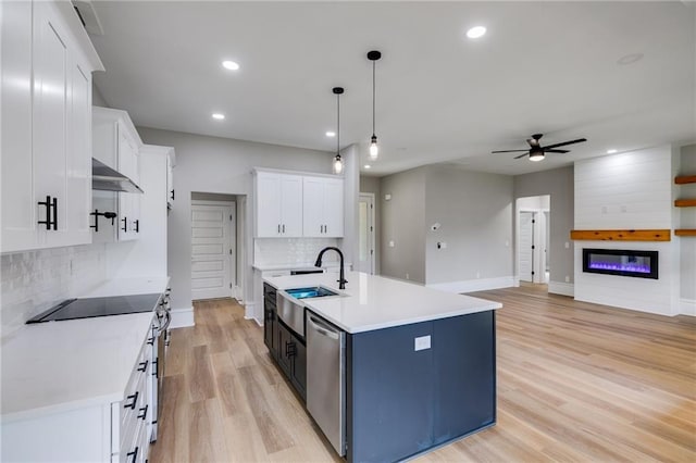 kitchen featuring white cabinetry, stainless steel appliances, a sink, extractor fan, and a ceiling fan
