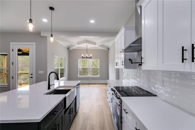 kitchen featuring wall chimney exhaust hood, tasteful backsplash, appliances with stainless steel finishes, a sink, and coffered ceiling