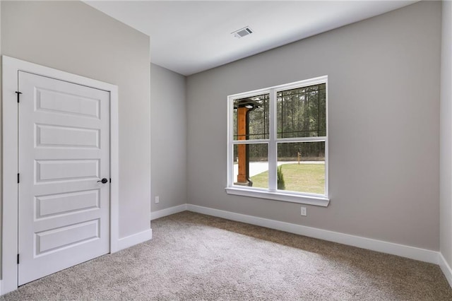 spare room with baseboards, carpet floors, and visible vents