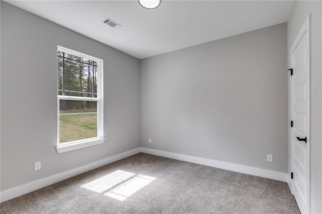 spare room featuring baseboards, visible vents, and carpet floors