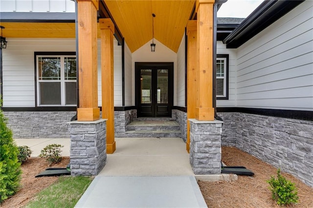 doorway to property with stone siding and french doors