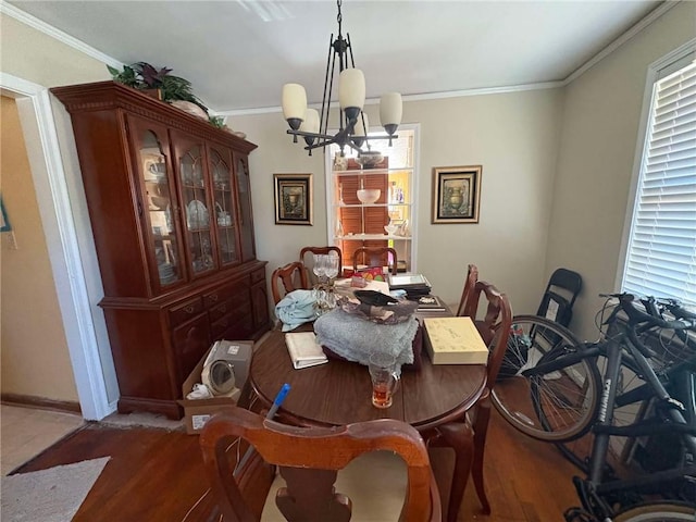 dining area with dark hardwood / wood-style flooring, ornamental molding, and a chandelier