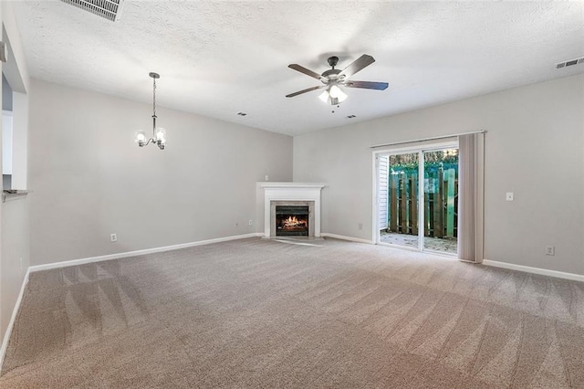 unfurnished living room featuring carpet, ceiling fan with notable chandelier, and a textured ceiling