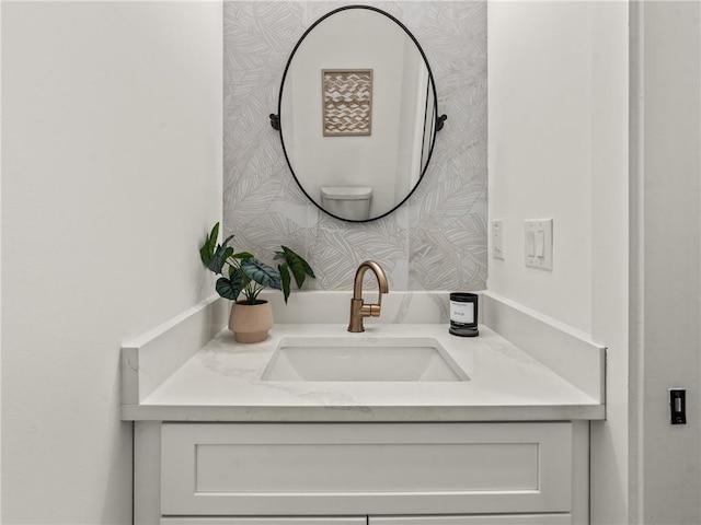 bathroom featuring wallpapered walls and vanity