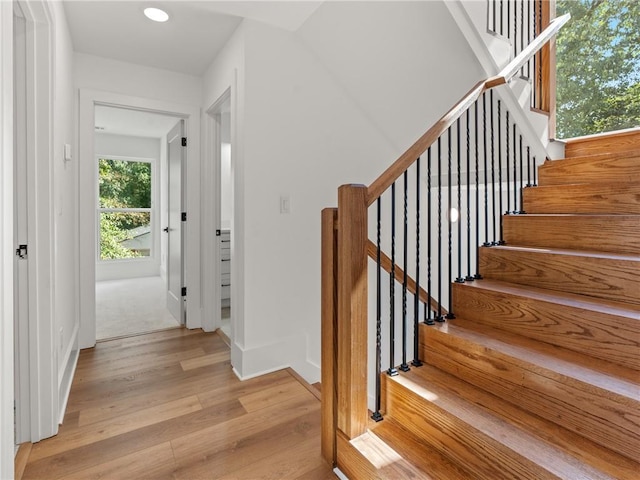 staircase with baseboards and wood finished floors