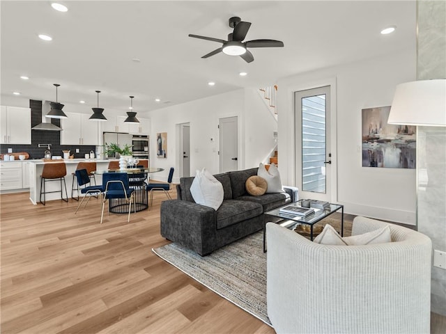 living room featuring light wood-type flooring and ceiling fan