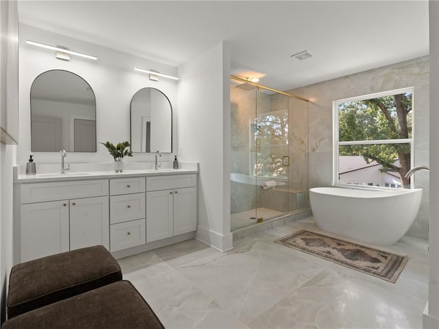 full bath featuring a stall shower, a soaking tub, a sink, and visible vents