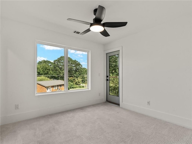 unfurnished room featuring ceiling fan, visible vents, baseboards, and light colored carpet