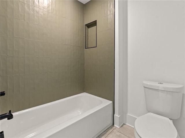 bathroom featuring a tub to relax in, tile patterned flooring, baseboards, and toilet