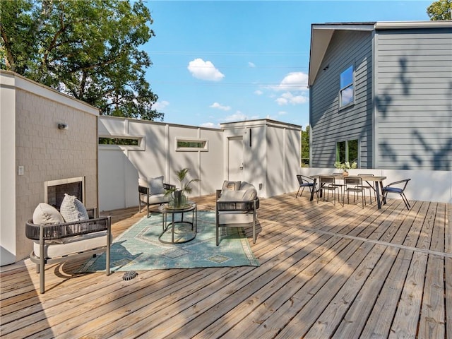 wooden terrace featuring outdoor dining space and an outdoor hangout area