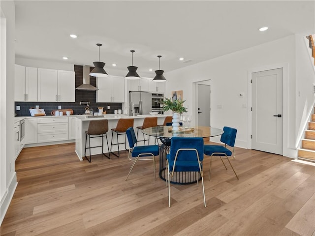 dining room with stairs, light wood-type flooring, and recessed lighting