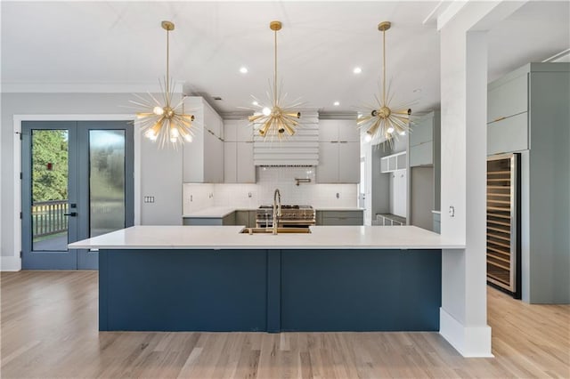 kitchen with gray cabinetry, backsplash, sink, and hanging light fixtures