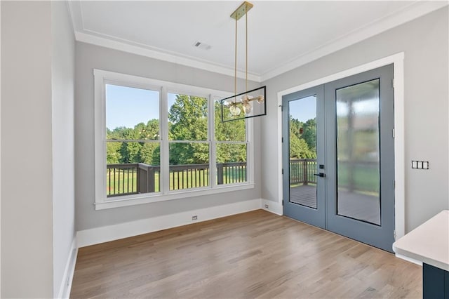 entryway with french doors, crown molding, a notable chandelier, and hardwood / wood-style floors