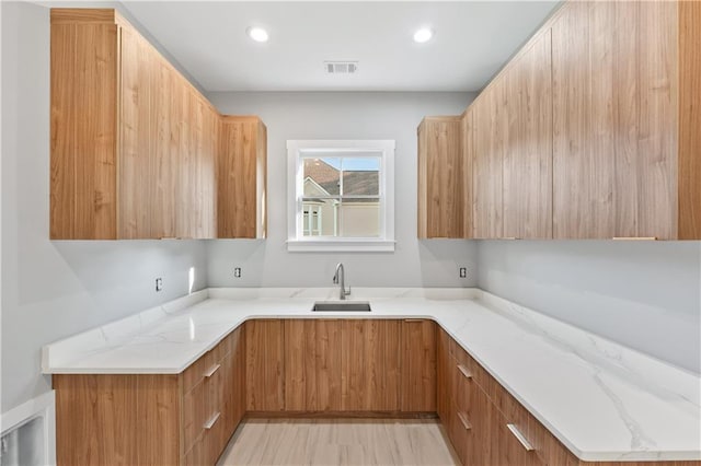 kitchen with light stone countertops and sink