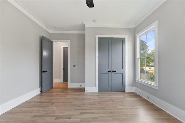 unfurnished bedroom with a closet, light hardwood / wood-style flooring, ceiling fan, and crown molding