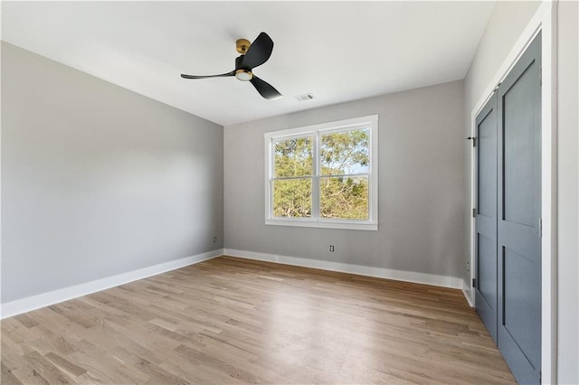 unfurnished bedroom featuring ceiling fan, light hardwood / wood-style flooring, and a closet