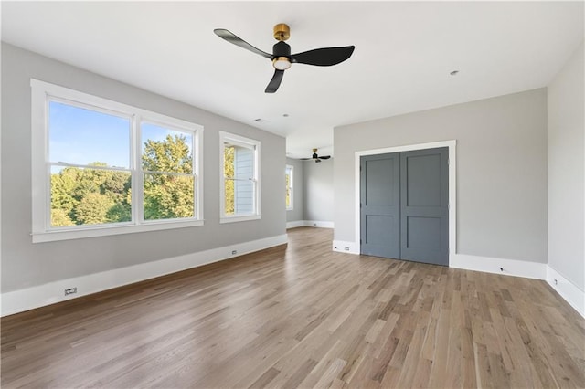 unfurnished bedroom featuring ceiling fan, a closet, and light wood-type flooring