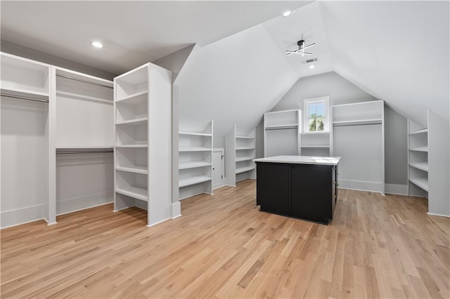 spacious closet featuring light hardwood / wood-style floors, ceiling fan, and lofted ceiling